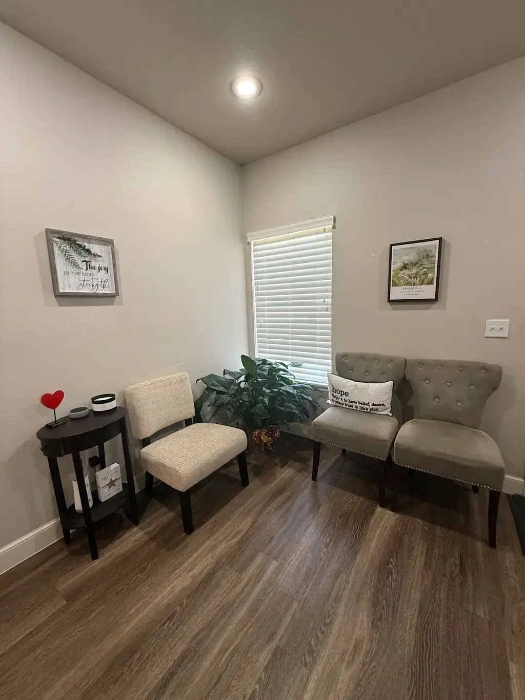 A quiet corner of the coaching room at The Hope Exchange, with an upholstered chair, a plant and framed scripture on the wall